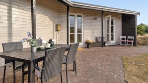 An outdoor patio with a table and chairs, a bench, and a covered area with chairs. - "Jules" - 300m from the sea by Interhome (Fanø)