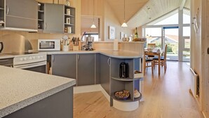 A modern kitchen with grey cabinets, a built-in oven, and a large island with a sink. - "Brynjolf" - 350m to the fjord by Interhome (Vinderup)