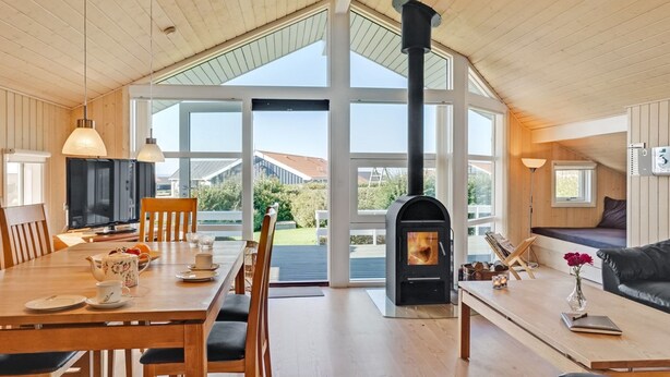 A spacious living area with a large fireplace, wooden furniture, and large windows offering a view of the outdoors. - "Brynjolf" - 350m to the fjord by Interhome (Vinderup)