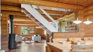 A log cabin interior with a wooden staircase, a dining area, and a living room with a fireplace. - "Elsia" - 1.5km to the fjord by Interhome (Frøstrup)