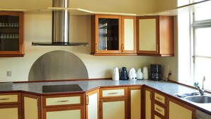 A kitchen with wooden cabinets, a stainless steel range hood, and a built-in oven. - "Thia" - 4km to the fjord by Interhome (Aabenraa)