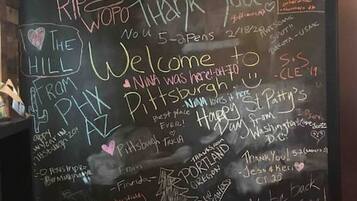 A blackboard with various handwritten messages and signatures, including names, locations, and expressions of gratitude.