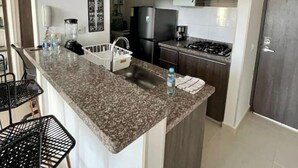 Eine moderne Küche mit Granit Arbeitsplatte, integrierten Geräten und dunklen Holzschränken.
