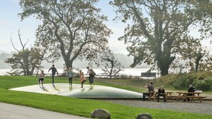 Un parc doté d’un espace aménagé pour le skate, de tables de pique-nique et de grands arbres.