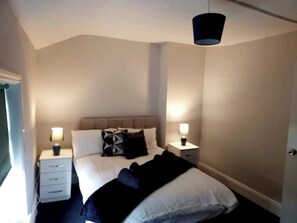 Comfortable accommodations feature a bed with a headboard, bedside tables, and a hanging light fixture.