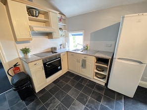 Enjoy cooking in this well-equipped kitchen with a sleek oven, stovetop, and refrigerator.