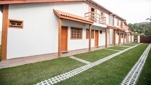 A building with a white exterior, wooden doors, and a tiled roof. - Paraíso em Balneário Camboriú - Praia do Estaleiro by ReservaStar (Balneário Camboriú)