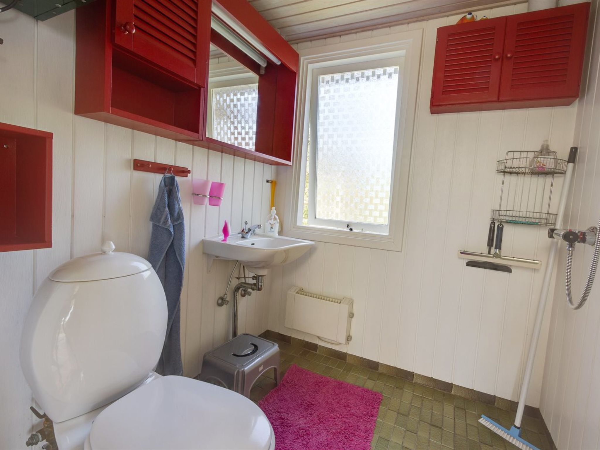 Un baño con inodoro, lavamanos y zona de ducha.