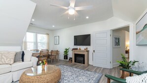 Ein geräumiges Wohnzimmer mit einer Couch, einem Couchtisch und einem Kamin.