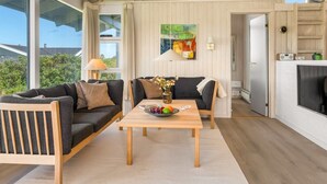 Ein moderner Wohnraum mit einer Sofagarnitur, einem Holztisch und einem Bild an der Wand.