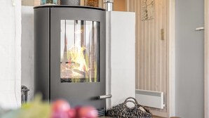 Ein modernes Zimmer mit Kaminofen, Heizkörper und einem gewebten Korb.