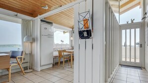 Una cocina moderna con un refrigerador blanco, armarios de madera y una zona de comedor con mesa y sillas.