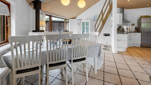 A modern kitchen with white cabinetry, a stainless steel refrigerator, and a wooden staircase. - "Reiner" - 300m to the fjord by Interhome (Skjern)
