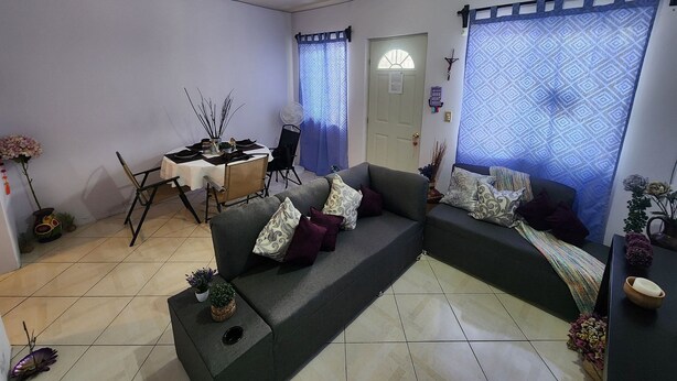 Ein Wohnzimmer mit einer Couch, einem Esstisch und einem Ventilator.