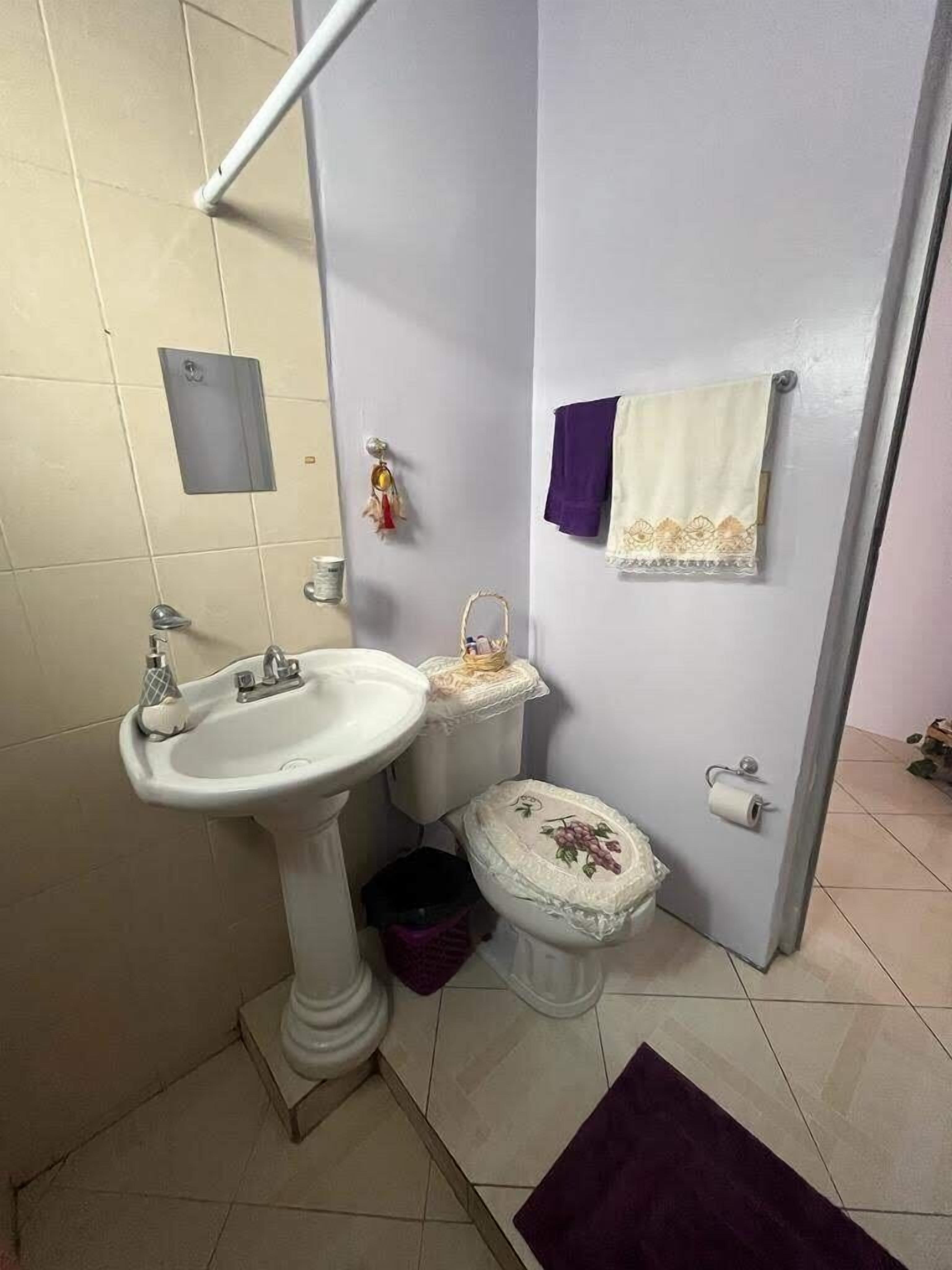 Un bagno con lavabo su piedistallo, water e portasciugamani.