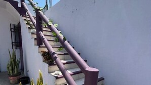Una escalera con barandas moradas que lleva a un nivel superior.
