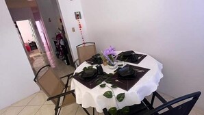 Comedor con una mesa redonda dispuesta para cuatro personas, rodeada de sillas.