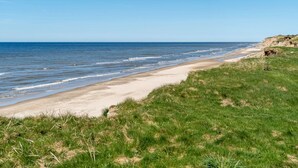 A beach with a grassy foreground and a clear view of the ocean. - "Trifun" - 50m from the sea by Interhome (Løkken)