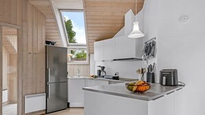Uma cozinha moderna com ilha central, forno embutido e uma janela ampla.