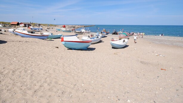 A beach with several small boats parked on the sand.