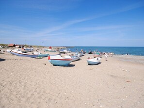 A beach with several small boats parked on the sand.
