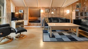 A cozy, wooden-furnished living room with a television, sofa, and coffee table. - "Thit" - 1.2km to the fjord by Interhome (Hemmet)