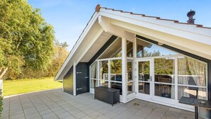 A modern house with a sloped roof, large glass windows, and a tiled patio. - "Thit" - 1.2km to the fjord by Interhome (Hemmet)