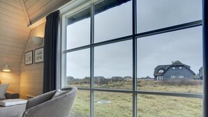 A room with a large window, a grey armchair, a sofa, and a lamp. - "Ege" - 200m from the sea by Interhome (Blåvand)
