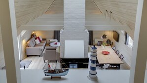 A modern interior with a loft-style dining area, a cozy seating area with sofas, and a visible ship model. - "Ege" - 200m from the sea by Interhome (Blåvand)