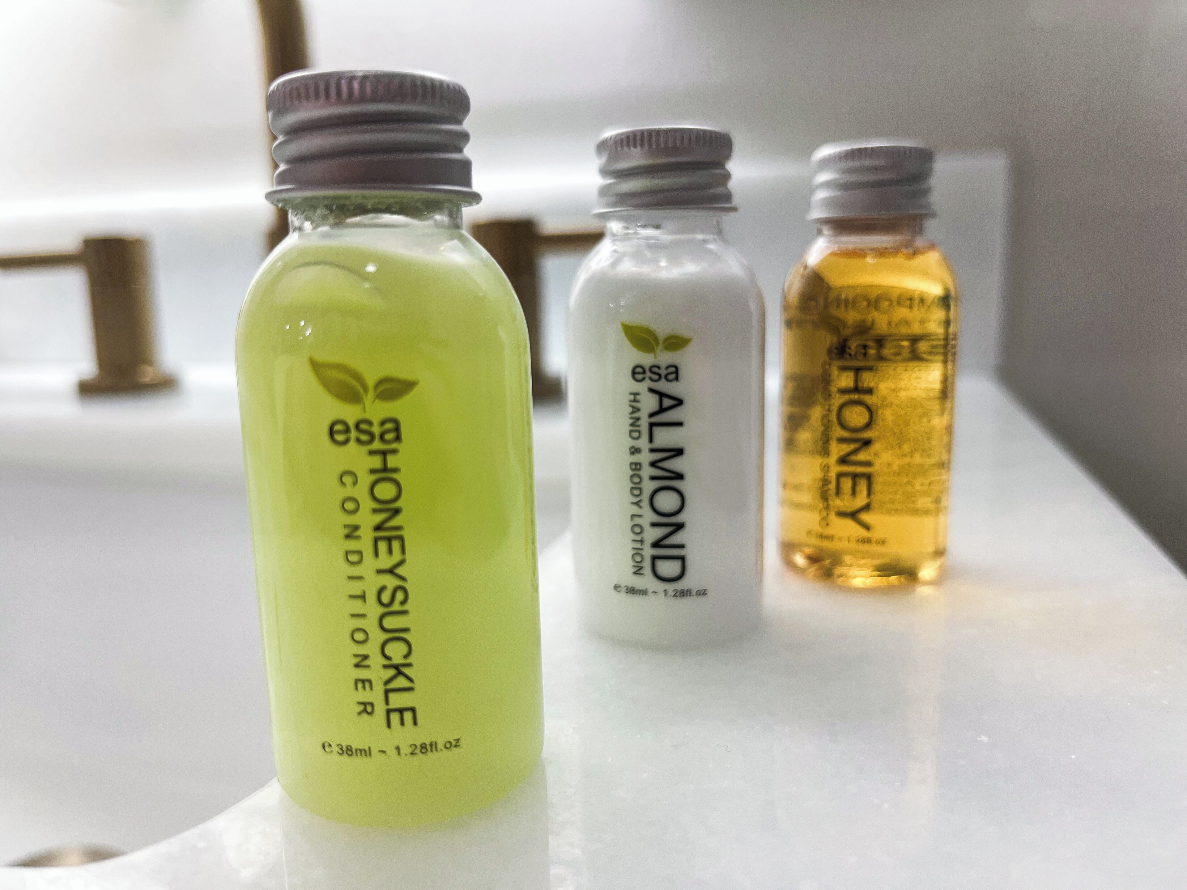 Tres botellas de loción sobre una superficie blanca.
