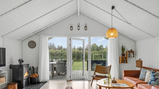 A cozy living room with a fireplace, a sofa, a coffee table, and a dining area with chairs. - "Ilsi" - 1.5km from the sea by Interhome (Blåvand)