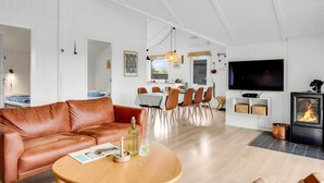 A modern living room with a leather sofa, dining area, TV, and fireplace. - "Ilsi" - 1.5km from the sea by Interhome (Blåvand)