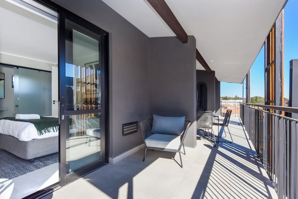 Enjoy the city view from your balcony with a sofa and table.