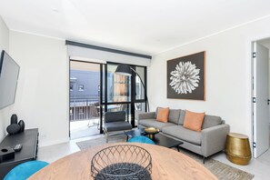 Relax in this stylish living room with a round dining table, comfortable sofa, and floor lamp.