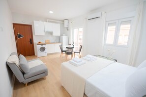 Une chambre d’hôtel comprenant un lit, un canapé, une table à manger et un coin cuisine.