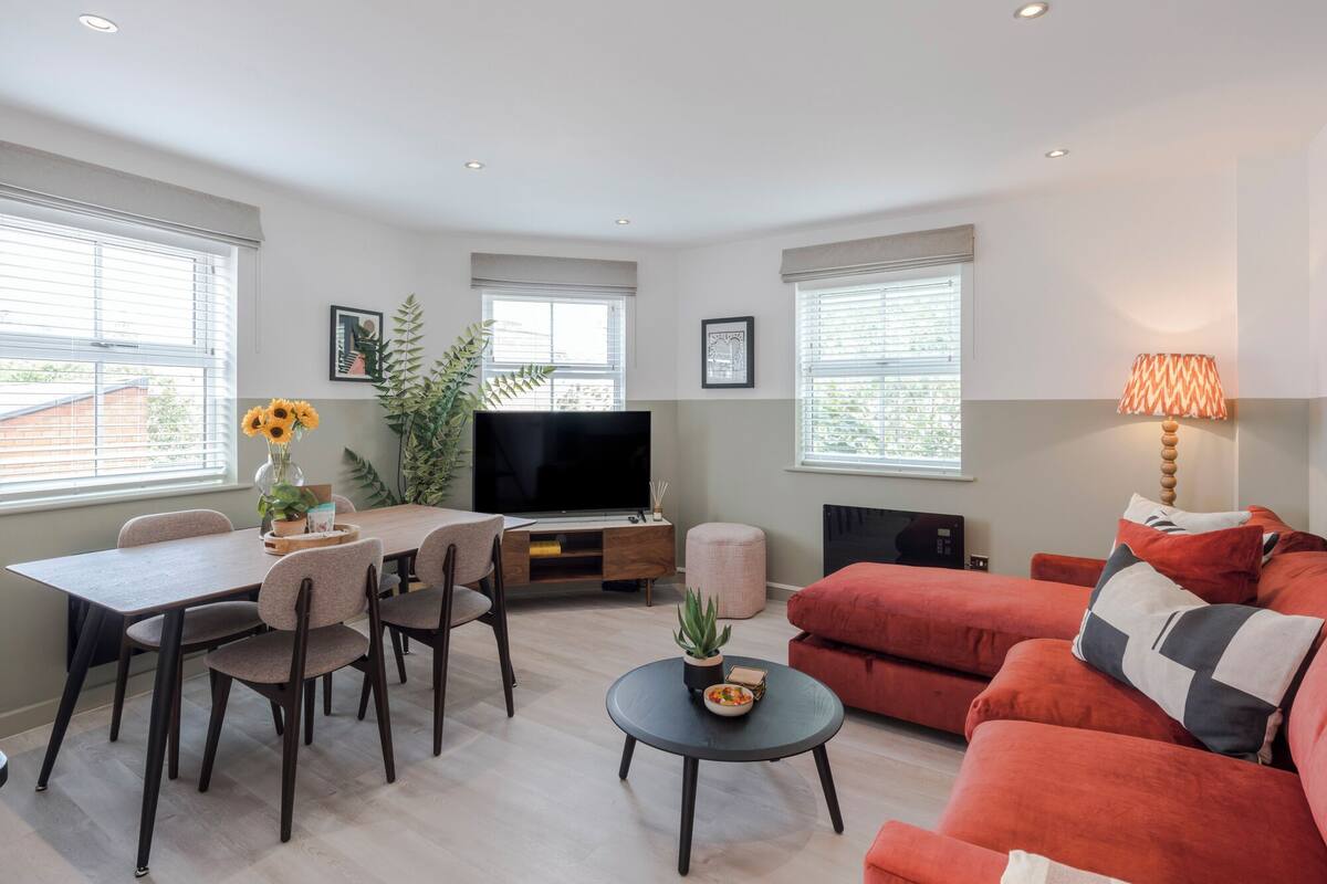 A modern living room with a dining area, a TV, and a sofa.