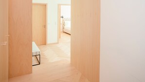 A hallway with wooden flooring and walls, leading to a bed in the distance. - Allegro Boutique Apartment 1A (Porto)