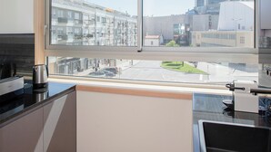 A modern kitchen with a large window offering a view of a cityscape. - Allegro Boutique Apartment 1A (Porto)