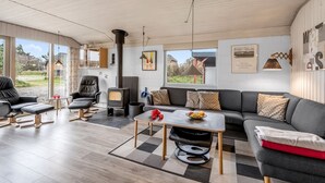 Una sala de estar moderna con chimenea, sofá y mesa de comedor.