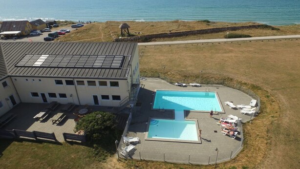 A building with a swimming pool and a beach view.