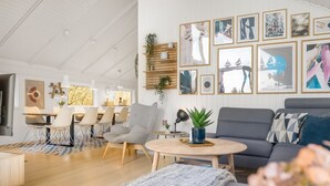 Een moderne woonkamer met een bank, salontafel en een eethoek.