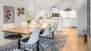 Een moderne keuken met witte kasten, een houten eiland en hanglampen.