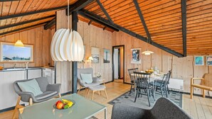 A modern interior with a dining area, kitchen, and seating space. - "Hildegart" -  from the sea by Interhome (Hvide Sande)