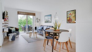 A modern living room with a sofa, dining table, chairs, and a view of the outdoors. - "Sipi" - 100m from the sea by Interhome (Hals)