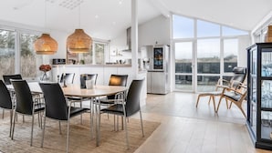 Una cocina moderna con comedor, ventanas amplias y vista a la ciudad.
