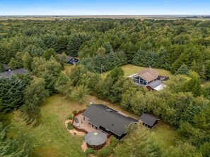A residential area with multiple houses surrounded by dense forest.