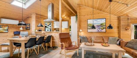 A spacious cabin interior with a dining area, a kitchen, and a living room.
