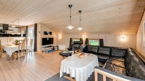 Un espacio habitable amplio con una mesa de comedor, un sofá y una televisión.
