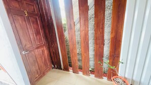 A wooden door with a number '3' and a potted plant near the entrance.