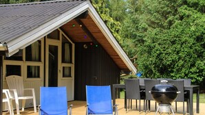 A wooden deck with two blue lounge chairs, a barbecue grill, and a dining table with chairs. - "Hildegarda" - 1km from the sea by Interhome (Sæby)